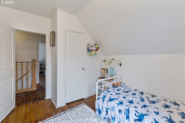 bedroom with dark wood-style floors and lofted ceiling