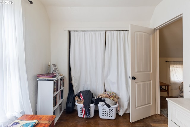 bedroom with vaulted ceiling and dark wood finished floors