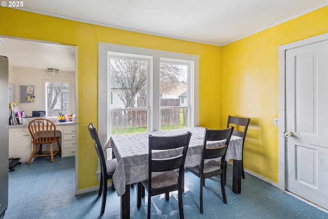 dining space with baseboards, ornamental molding, a wealth of natural light, and tile patterned floors