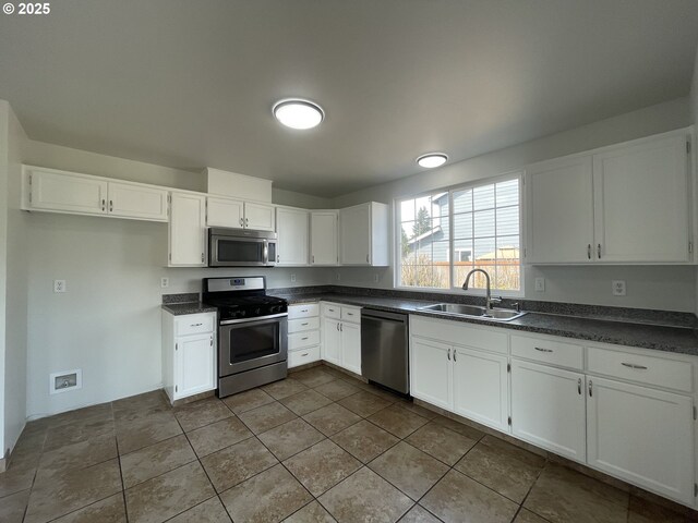 5145 Trevon St, Eugene, OR 97402 - kitchen featuring appliances with stainless steel finishes, dark countertops, and white cabinets