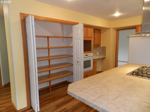 31811 NW Belgium Ct, North Plains, OR 97133 - kitchen featuring oven, ventilation hood, wood finished floors, and stainless steel gas stovetop