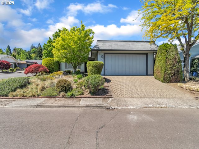 single story home with an attached garage and decorative driveway