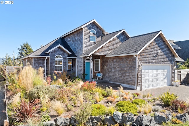 shingle-style home featuring an attached garage, a shingled roof, and concrete driveway