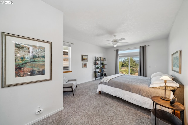 carpeted bedroom featuring baseboards and ceiling fan