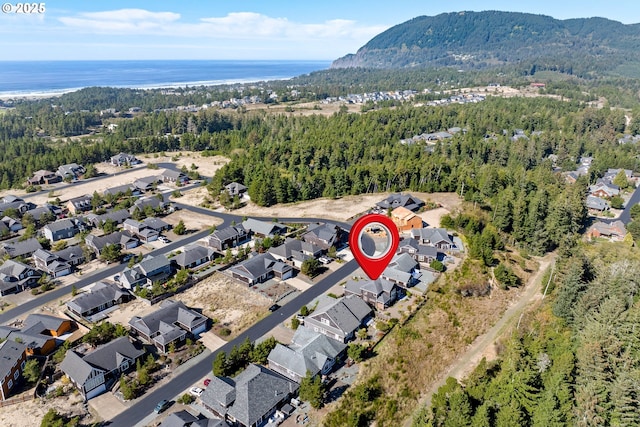 aerial view with a water view and a wooded view