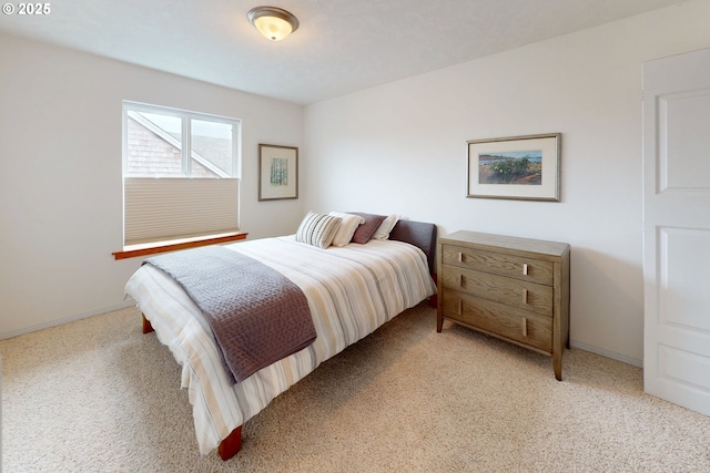 bedroom featuring baseboards and light carpet