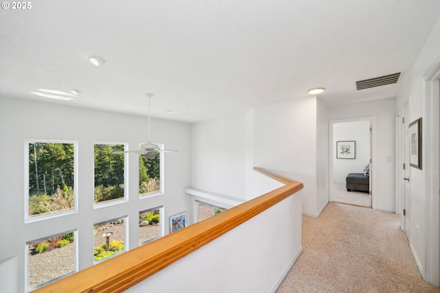 corridor featuring light carpet, visible vents, and an upstairs landing