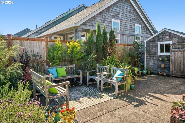 view of patio with an outbuilding, fence, and a storage unit