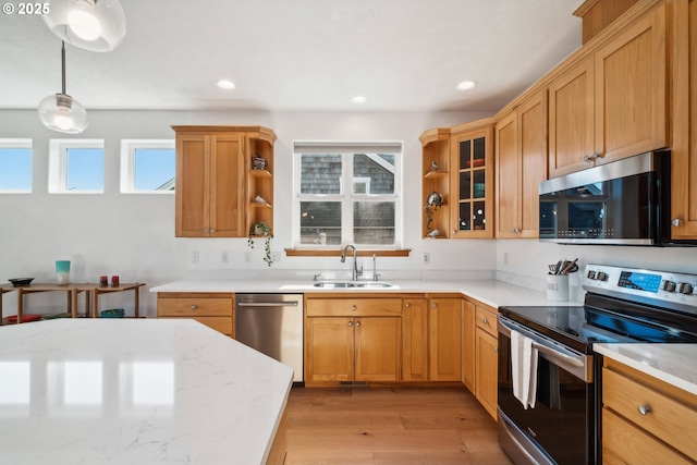 kitchen with a healthy amount of sunlight, a sink, appliances with stainless steel finishes, and open shelves