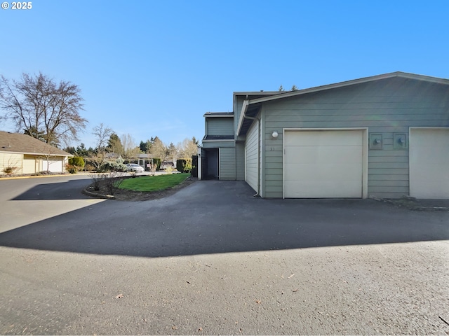 view of property exterior with a garage and driveway