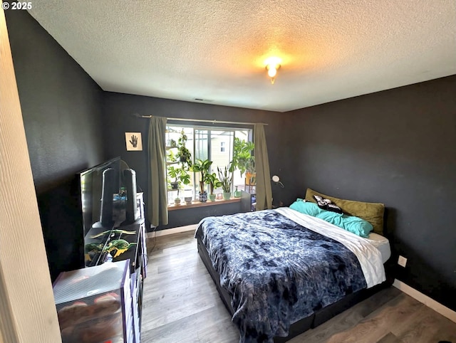 1912 SE 122nd Ave Unit 11, Portland, OR 97233 - bedroom with a textured ceiling, wood finished floors, and baseboards