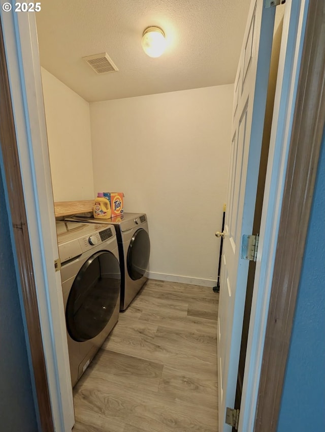 1912 SE 122nd Ave Unit 11, Portland, OR 97233 - laundry area featuring washer and dryer, light wood-style floors, a textured ceiling, and baseboards