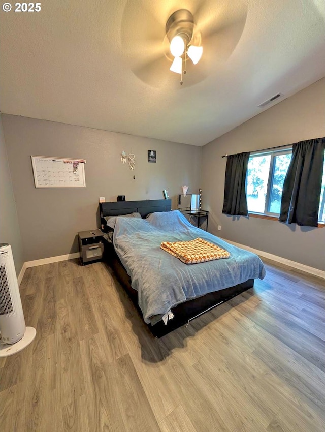 1912 SE 122nd Ave Unit 11, Portland, OR 97233 - bedroom featuring lofted ceiling, wood finished floors, a textured ceiling, a ceiling fan, and baseboards