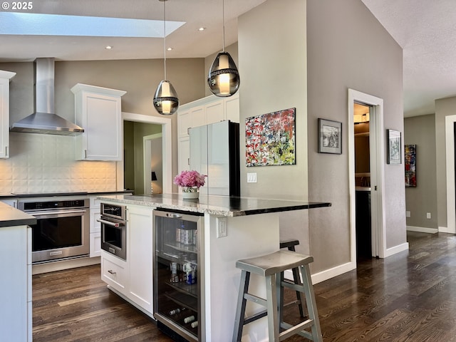 24035 SW Mountain Creek Rd, Sherwood, OR 97140 - kitchen featuring stainless steel oven, wine cooler, wall chimney exhaust hood, freestanding refrigerator, and dark wood-style floors