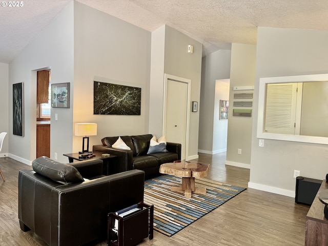 24035 SW Mountain Creek Rd, Sherwood, OR 97140 - living area featuring wood finished floors, baseboards, a textured ceiling, and high vaulted ceiling