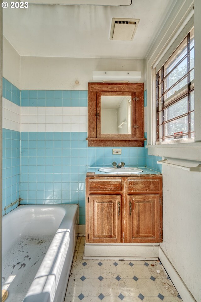 3807 NE Grand Ave, Portland, OR 97212 - bathroom with tile patterned floors, visible vents, vanity, and a bathing tub
