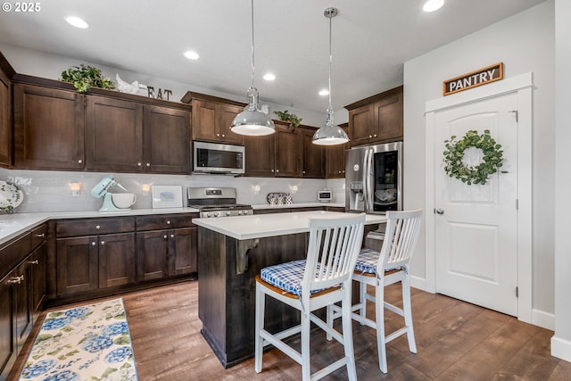 52152 Casswell Dr, Scappoose, OR 97056 - kitchen featuring stainless steel appliances, dark brown cabinets, tasteful backsplash, wood finished floors, and light countertops