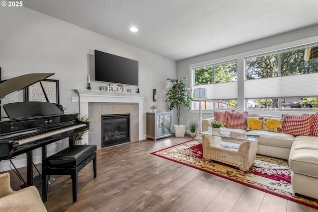 52152 Casswell Dr, Scappoose, OR 97056 - living area with a textured ceiling, wood finished floors, a tile fireplace, and recessed lighting