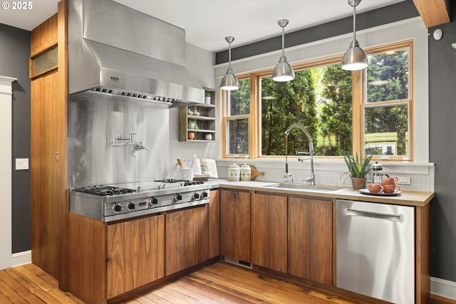 4000 NE Hassalo St, Portland, OR 97232 - kitchen featuring wall chimney range hood, appliances with stainless steel finishes, a sink, brown cabinetry, and decorative backsplash