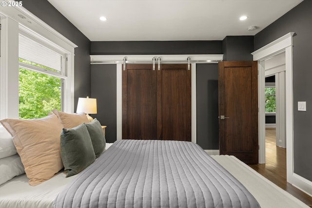 4000 NE Hassalo St, Portland, OR 97232 - bedroom featuring wood finished floors, multiple windows, recessed lighting, baseboards, and a barn door