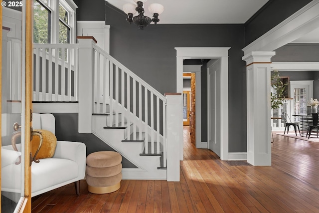 4000 NE Hassalo St, Portland, OR 97232 - stairway with wood-type flooring, a chandelier, baseboards, and decorative columns