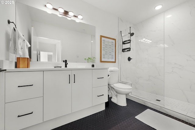 bathroom with tile patterned flooring, toilet, vanity, and tiled shower