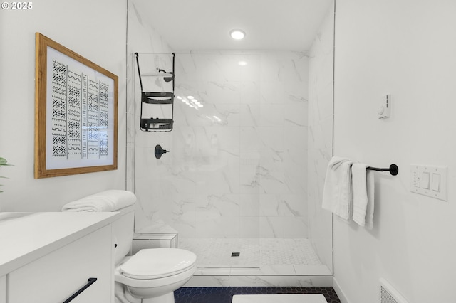 bathroom with a tile shower, tile patterned flooring, and toilet