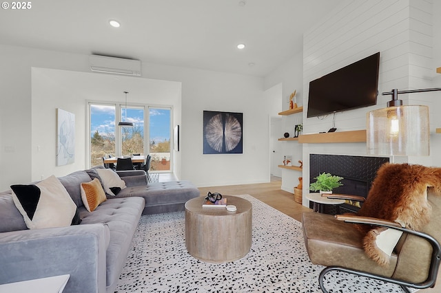 living room featuring a wall mounted air conditioner and light wood-type flooring