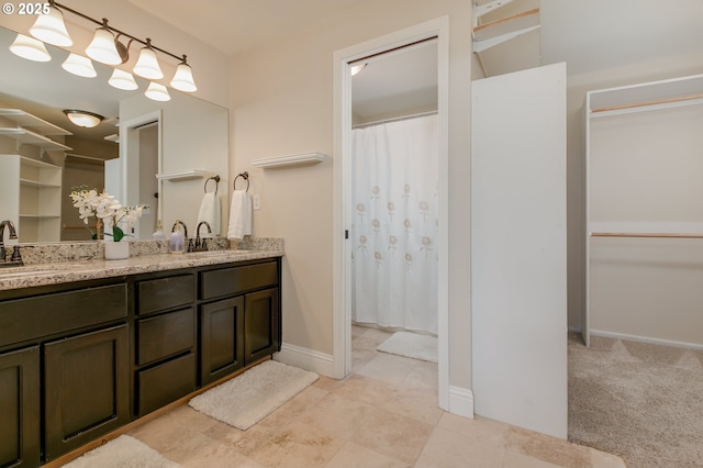 full bathroom with a sink, baseboards, double vanity, and a shower with shower curtain