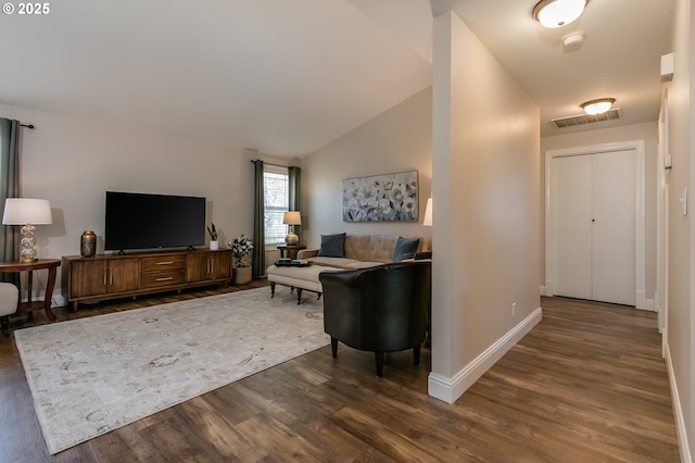 living area with baseboards, visible vents, dark wood-style floors, and vaulted ceiling