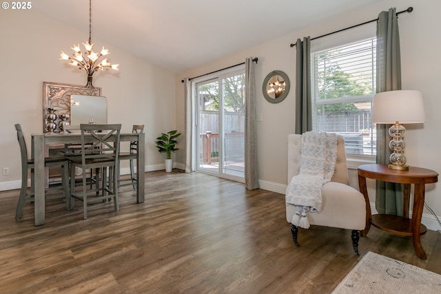 dining area featuring an inviting chandelier, baseboards, wood finished floors, and vaulted ceiling