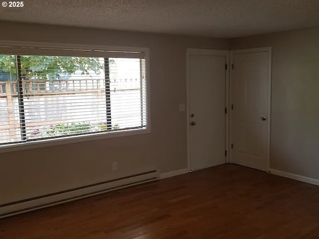 11181120 SE 45th Ave, Portland, OR 97215 - empty room with wood finished floors, a baseboard radiator, healthy amount of natural light, baseboards, and a textured ceiling