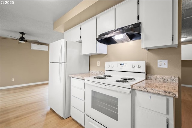 kitchen with white appliances, under cabinet range hood, light wood finished floors, baseboards, and light countertops