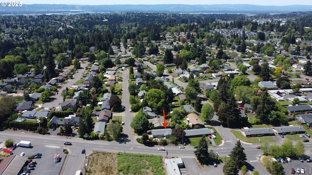 view of property location with a forest, mountains, and nearby suburban area