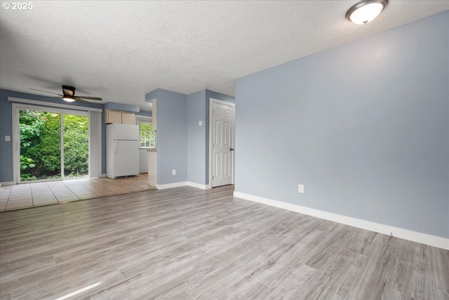 unfurnished living room featuring a ceiling fan, baseboards, light wood-style flooring, and a textured ceiling