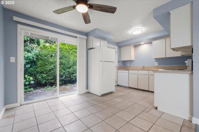 kitchen with white appliances, light countertops, ceiling fan, a sink, and white cabinetry