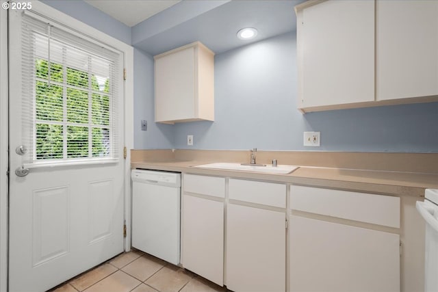 kitchen with dishwasher, a sink, light countertops, light tile patterned flooring, and white cabinetry