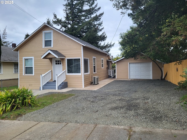 bungalow-style house featuring an outbuilding, a garage, and central AC unit