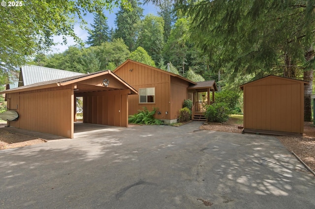 10268 Field Crest Dr, Birkenfeld, OR 97016 - view of front of house with a shed, asphalt driveway, an attached carport, and a metal roof