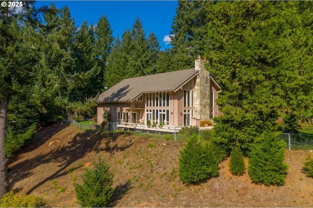 rear view of house featuring a wooden deck