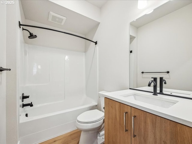 full bathroom with bathing tub / shower combination, hardwood / wood-style floors, vanity, and toilet