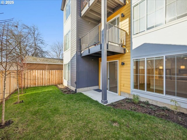 rear view of property with a yard, a patio, and a balcony