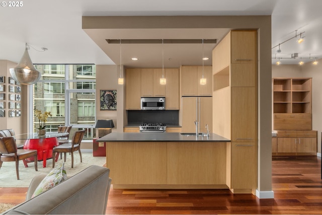 kitchen with appliances with stainless steel finishes, dark countertops, dark wood-type flooring, modern cabinets, and light brown cabinetry