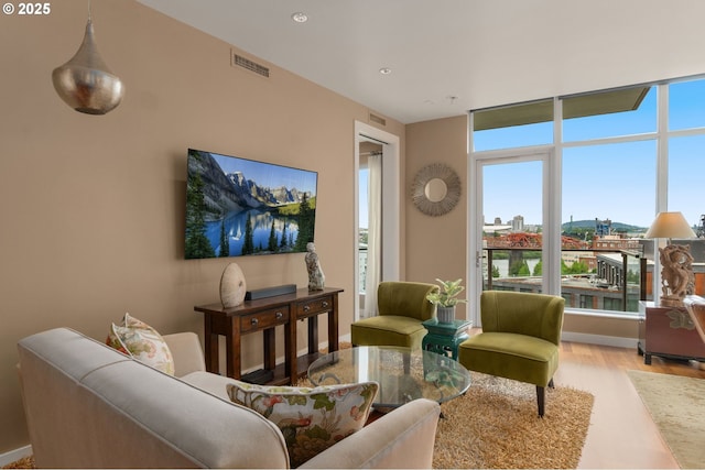 living room with plenty of natural light, wood finished floors, and recessed lighting