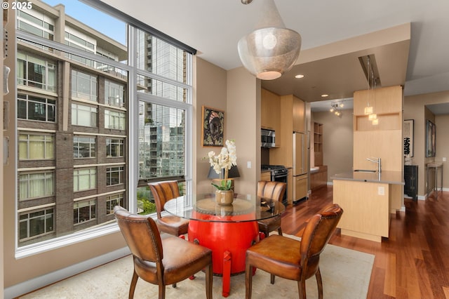 dining area featuring wood finished floors, baseboards, and recessed lighting