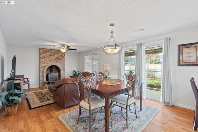 dining space featuring ceiling fan, light hardwood / wood-style flooring, and a textured ceiling