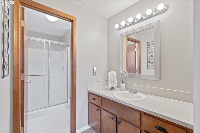 bathroom featuring vanity, a textured ceiling, and walk in shower