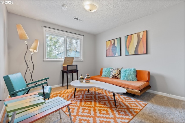 carpeted living room featuring a textured ceiling