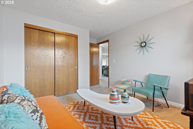 sitting room featuring light carpet and a textured ceiling