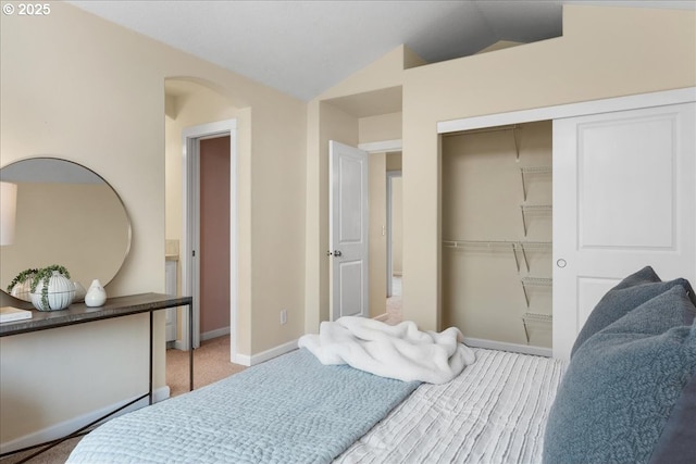 bedroom with lofted ceiling, carpet floors, and a closet